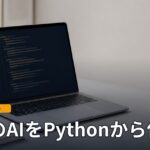 机の上で開いたノート型Macの画面にコードが表示されている様子